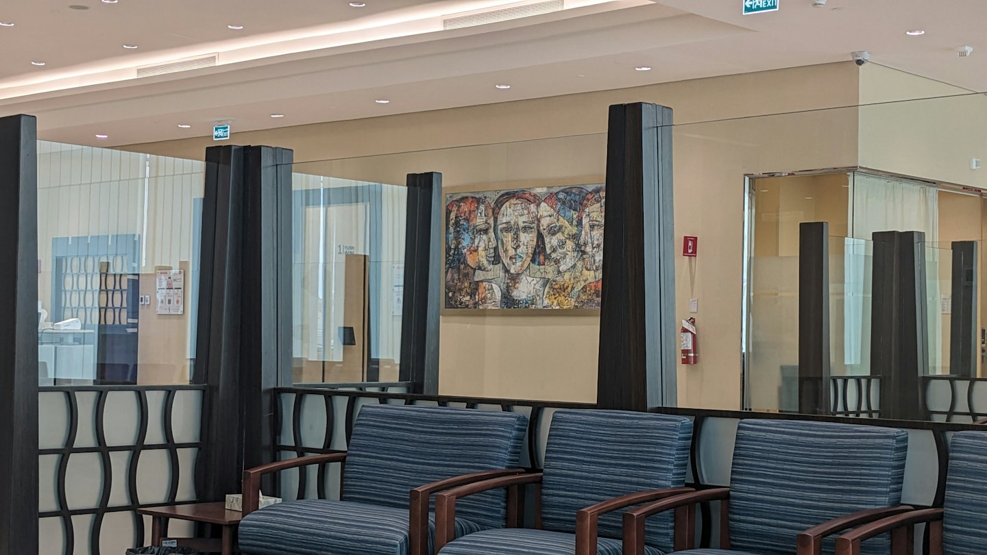 Empty modern waiting room with striped armchairs and abstract art.